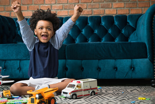 Happy and yippee black people African American child with toy and sofa at home 