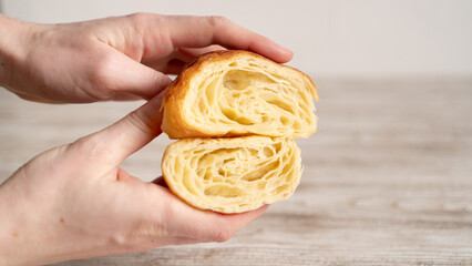 The honeycomb structure of the croissant. Hand holding Classic and buttery French Croissants