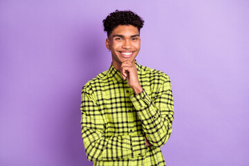 Photo of smart minded young afro american man hold hand chin smile isolated on purple color background