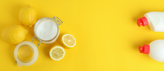 Jar of acid powder, lemons and detergents on yellow background