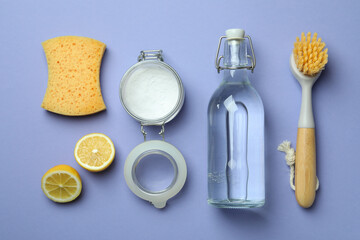 Flat lay with cleaning tools on violet background