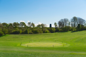 Fototapeta na wymiar Public golf course and parkland with Black mill on horizon in spring. Beverley, UK.