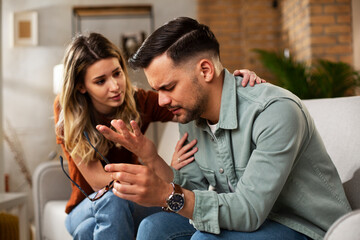 Young man having a problem. Girlfriend comforting her sad boyfriend.