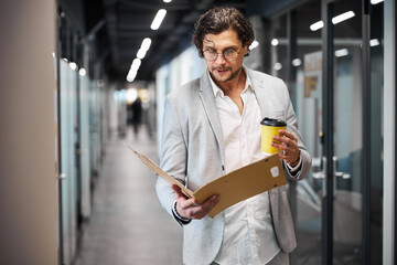 Attentive brunette man looking at opened folder