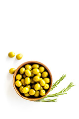Wooden bowl with green olives. Overhead view, space for text