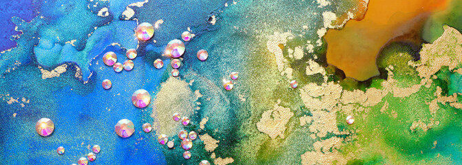 art photography of abstract fluid art painting with alcohol ink blue, green, gold colors and crystal rhinestones