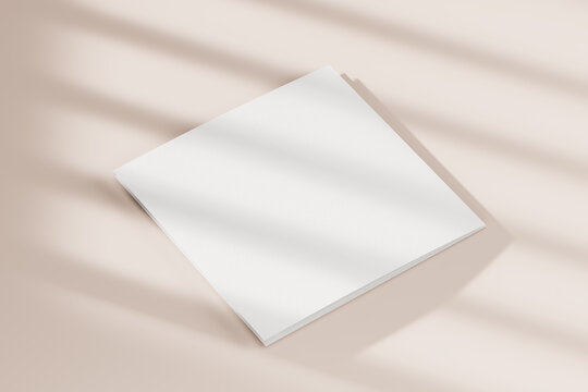 Blank square booklet on beige background with folded edge shadows. Mock up. 3d rendering.