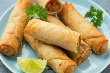 Fried spring rolls with sweet chili sauce and lime on plate