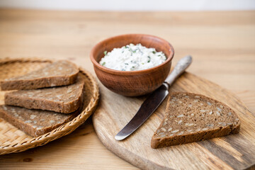 Whole grain bread bruschetta with white soft curd cream cheese on a ginger grunge background.