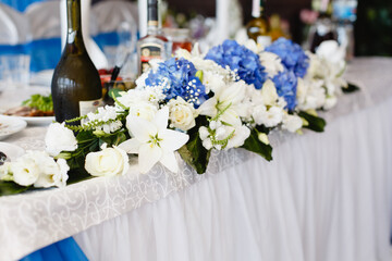 Beautiful floristic decor for wedding table with blue details