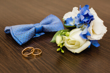 Groom's morning. Wedding accessories in blue colors. Tie-butterfly, watch and boutonniere