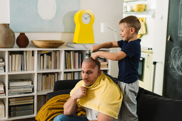 boy playing hairdresser with his father