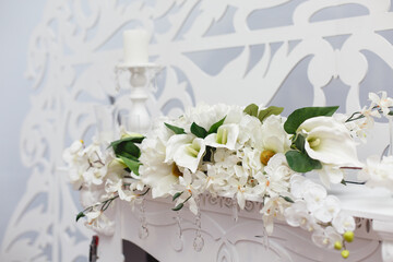 Elegant white fireplace on beautiful white toreutic background. Elegant wedding ceremony