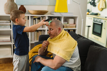 boy playing hairdresser with his father