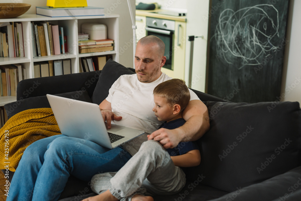 Wall mural father and son using laptop computer