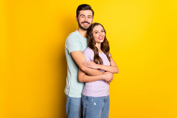 Fototapeta premium Portrait of attractive gentle cheerful couple embracing honeymoon day isolated over bright yellow color background