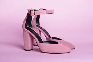 Female pink high heel shoes suede leather isolated on a pink background