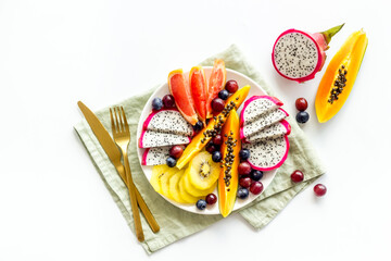 Group of tropical fruits in plate. Exotic breakfast with mango and dragon fruit. Top view