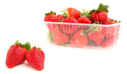 fresh appetizing strawberries in a plastic tray onwhite background