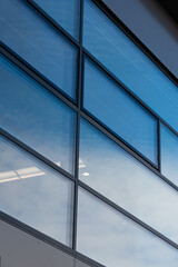 Rectangular windows, blue panes in a modern office building with a gray graphite wall 