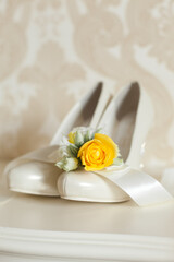 Wedding accessories: Bride's shoes and boutonniere in yellow colors