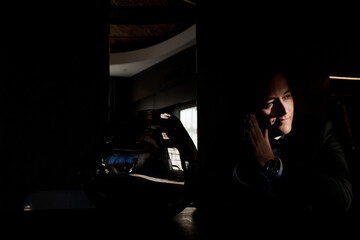 Close up of young groom is waiting for the wedding ceremony in a dark hotel room. Concept of groom morning