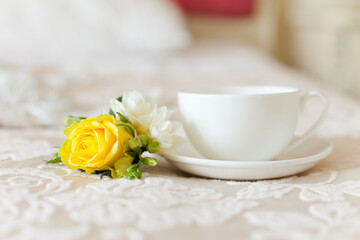 A cup of tea and yellow flower near it. Morning coffee