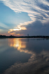 Wonderful sunset with unusual clouds at lake and City Park in Rishon Le Zion. Warm autumn evening. Natural landscape. Israel