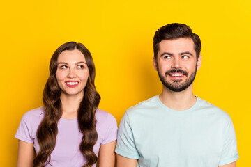 Fototapeta premium Portrait of attractive curious cheerful couple thinking fantasizing isolated over bright yellow color background
