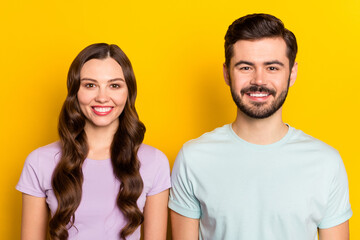 Portrait of attractive cheerful glad couple coworkers isolated over vibrant yellow color background