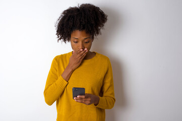 young beautiful African American woman wearing yellow sweater against white wall being deeply...