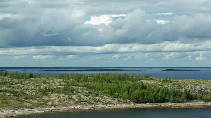 View of the sea and sky from a high point. Harsh northern nature. Rocky island overgrown with...