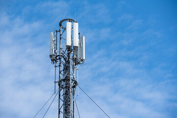 Silver antenna on the background of blue sky and clouds during the day 