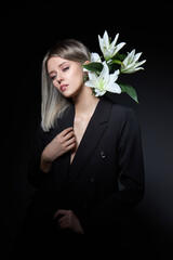 Woman colored hair color of a blonde with lily flower on black background. Coloring hair woman...