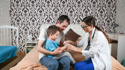 Obraz premium The doctor treats the child's hand at home
