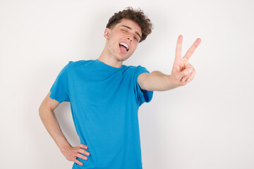 Fototapeta premium young caucasian handsome man with curly hair wearing blue T-shirt against white studio background directs fingers at camera selects someone. I recommend you. Best choice