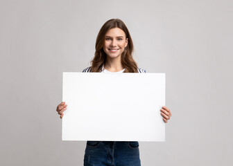 Smiling Millennial Lady Holding Blank Placard With Copy Space For Advertisement
