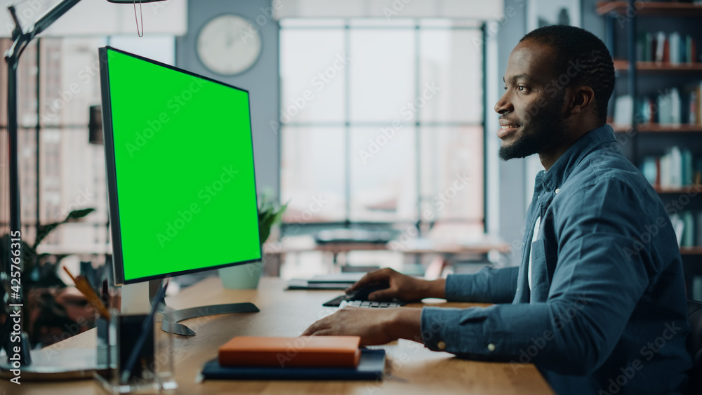 Poster handsome black african american specialist working on desktop computer with green screen mock up dis