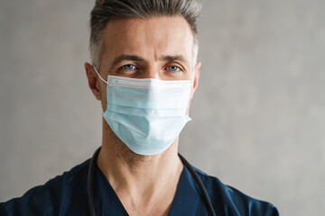 Confident mid aged doctor in protective medical mask