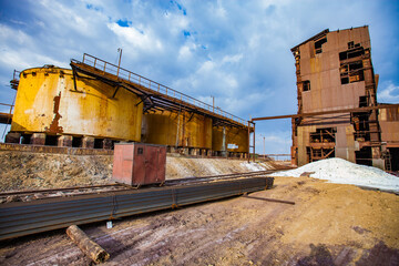 Fototapeta na wymiar Demolition of outdated Soviet sulfuric acid plant industrial building. Outside view. Title on storage tank: Danger. Sulfuric Acid.