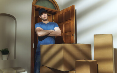 Delivery man next to the cardboard boxes.