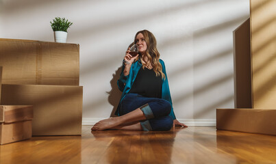 Tired woman with glass of wine after moving to a new flat.