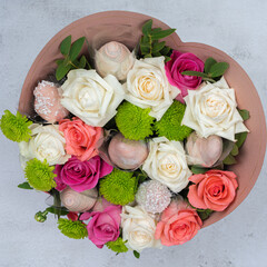 Edible bouquet of sweets, flowers and glazed strawberries.  On a light background. View from the top. A beautiful gift. Holiday concept