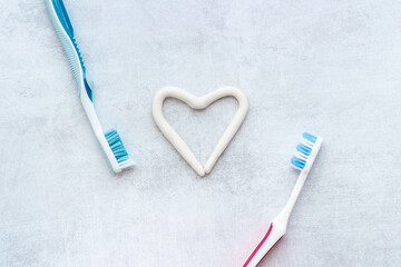 Teeth hygiene. Toothbrush with heart shape made of toothpaste, top view