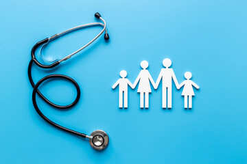 Health care and family doctor concept. Family figure with stethoscope, top view