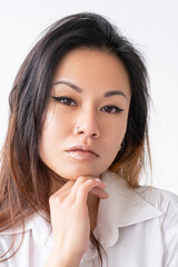 Fototapeta premium Beauty portrait. Facial care. Skin rejuvenation. Aesthetic cosmetology. Confident Asian woman with flawless face nude makeup isolated on white background.