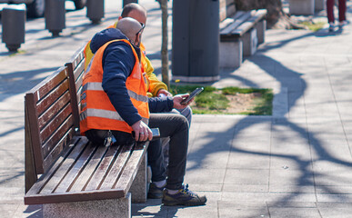 Two italian workers during a break relax looking at the cell phone