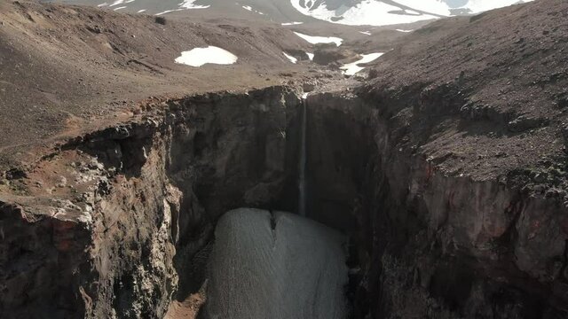 Picturesque landscape of Kamchatka: beautiful view of Dangerous Canyon (Opasny Canyon), waterfall on Vulkannaya River under active Mutnovsky Volcano. Eurasia, Kamchatka Peninsula, Russian Far East.