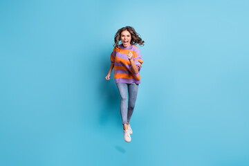 Full length portrait of astonished running fast girl open mouth shout isolated on blue color background