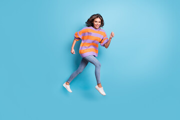 Full size profile photo of pretty cheerful lady running look camera have good mood isolated on blue color background